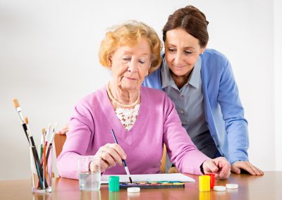 senior-female-painting-with-caregiver